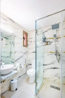 a bathroom with a glass shower and a toilet at Vittoria Guest House Marrakech in Marrakech