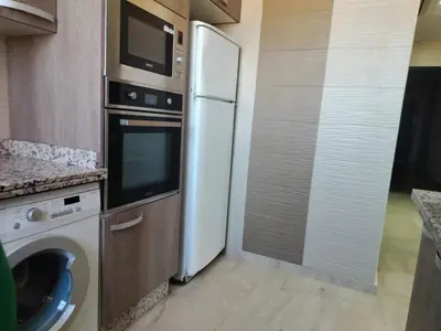 a kitchen with a refrigerator and a washing machine at résidence assafa central H26 in Marrakech