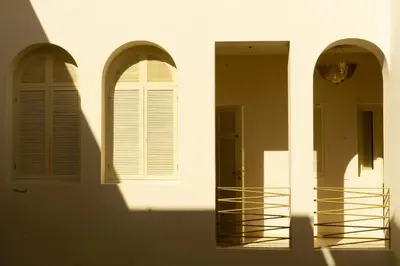 three arched windows on a white building at Riad Romeo in Marrakech