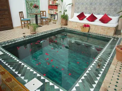 a large swimming pool in a living room at Riad Ocallaghan in Marrakech