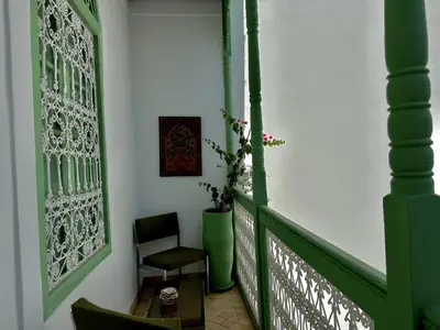 a green corridor with a chair and a table at Riad Ocallaghan in Marrakech