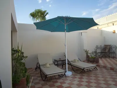 two chairs and an umbrella on a patio at Riad Ocallaghan in Marrakech