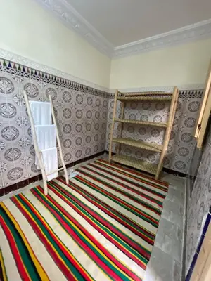a room with a colorful rug and shelves on the wall at Riad Fridi in Marrakech