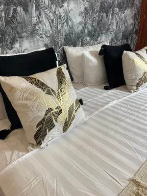 a bed with white sheets and pillows on it at Riad Amazing Amazigh avec jacuzzi petit déjeuner compris avec aussi chambres familiales près de la place jemaa El fna in Marrakech
