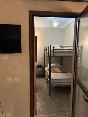 a room with two bunk beds and a flat screen tv at Riad Amazing Amazigh avec jacuzzi petit déjeuner compris avec aussi chambres familiales près de la place jemaa El fna in Marrakech
