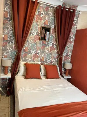 a bedroom with a bed with red curtains at Riad Amazing Amazigh avec jacuzzi petit déjeuner compris avec aussi chambres familiales près de la place jemaa El fna in Marrakech