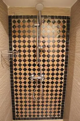 a shower in a bathroom with a checkered wall at E-Appartement de luxe centre Gueliz piscine parking fibre netflix in Marrakech