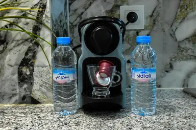 a blender and two bottles of water on a counter at E-Appartement de luxe centre Gueliz piscine parking fibre netflix in Marrakech