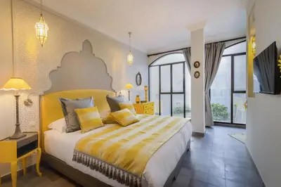 a bedroom with a large bed with yellow and white sheets at Riad Sybil Boutique Hotel in Marrakech