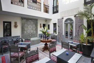 a restaurant with tables and chairs and a dog sitting in the middle at Riad Sybil Boutique Hotel in Marrakech