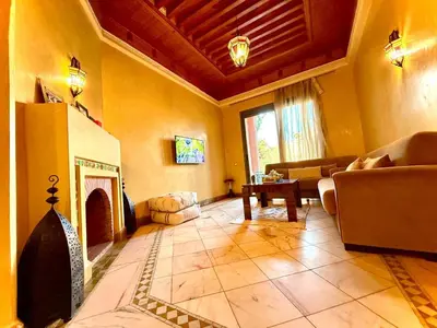 a living room with a couch and a fireplace at Les jardins de la palmeraie résidence touristique in Marrakech