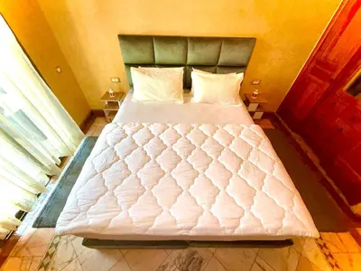 a bedroom with a large bed with white sheets and pillows at Les jardins de la palmeraie résidence touristique in Marrakech
