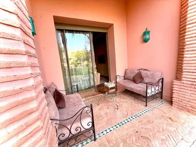 a patio with two chairs and a couch and a table at Les jardins de la palmeraie résidence touristique in Marrakech