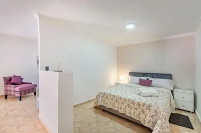 a bedroom with a bed and a pink chair at Cosy apartment in the heart of Hivernage in Marrakech