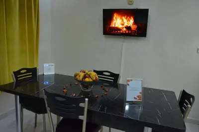 a table with a bowl of fruit and a fireplace at Riad Bollywood- family charm in Benguerir