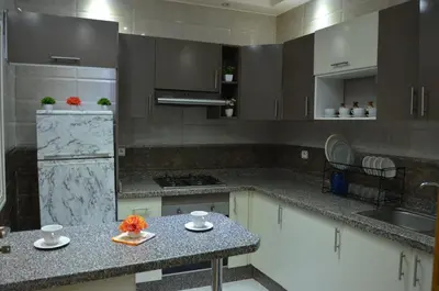 a kitchen with white cabinets and a counter top at Riad Bollywood- family charm in Benguerir