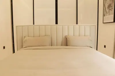 a white bed with two pillows in a bedroom at Duplex piscine chauffée terrasse in Marrakech