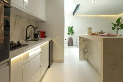 a white kitchen with a sink and a counter at Duplex piscine chauffée terrasse in Marrakech