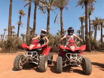 two people riding on atvs in the desert with palm trees at Quad Marrakech in Marrakech