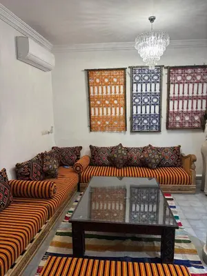 a living room with couches and a coffee table at Riad EL BADI in Marrakech