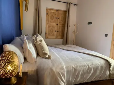 a bedroom with a bed with white sheets and pillows at Riad SunSet Marrakech in Marrakech