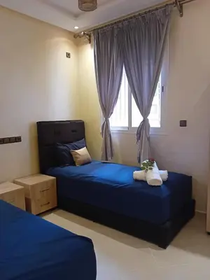 a bedroom with a blue bed and a window at Beautiful Apartment Near Airport in Marrakech