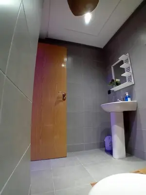 a bathroom with a wooden door and a sink at Beautiful Apartment Near Airport in Marrakech