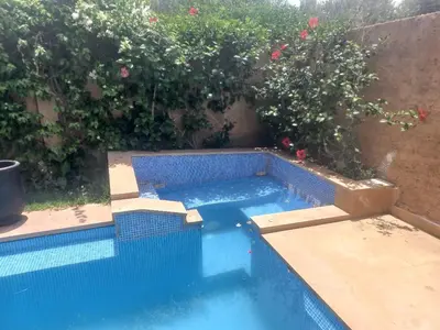 a swimming pool in a garden with flowers at H Amelkis in Marrakech