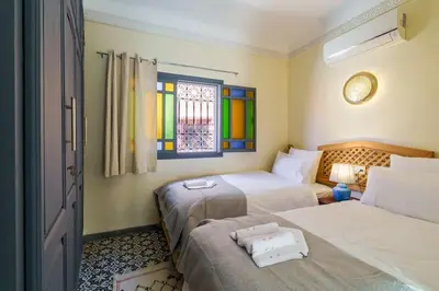 a bedroom with two beds and a stained glass window at Riad Taher Bed & Breakfast - Top position Médina in Marrakech