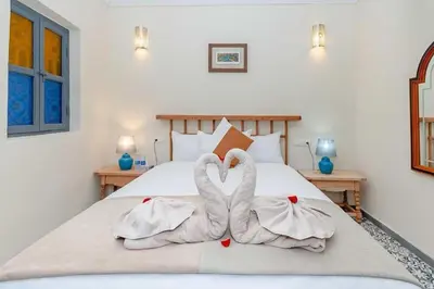 two swans are sitting on a bed at Riad Taher Bed & Breakfast - Top position Médina in Marrakech