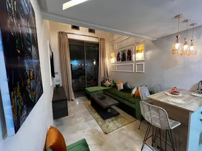 a living room with a green couch and a table at Nouvel appartement de luxe Pearl garden in Marrakech