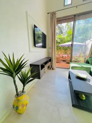 a living room with a plant in a large vase at Nouvel appartement de luxe Pearl garden in Marrakech