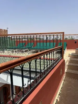 a railing on top of a building with chairs at Riad Anahata Marrakech in Marrakech