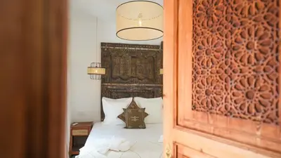 a bedroom with a bed with a large headboard at Riad Anahata Marrakech in Marrakech