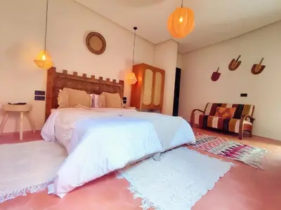 a bedroom with a large bed and a couch at Domaine Homa Marrakech in Marrakech