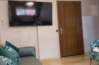 a living room with a couch and a flat screen tv at Luxury city center apartment with swimming pool in Marrakech