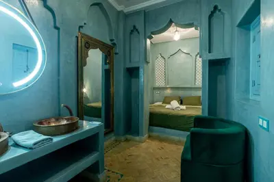 a bathroom with a sink and a bed with a mirror at Riad LALLA JIHANE in Marrakech