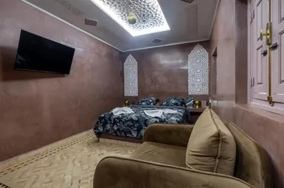 a bedroom with a bed and a flat screen tv at Riad LALLA JIHANE in Marrakech