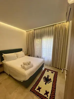 a bedroom with a bed with white sheets and a window at Premium Hivernage Amazigh 2BR Flat - Zayane Homes in Marrakech