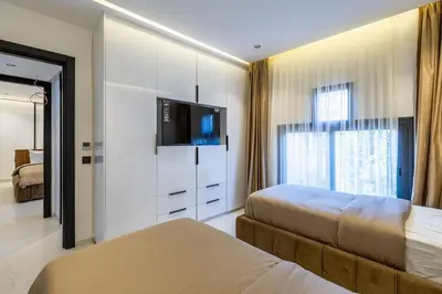 a bedroom with two beds and a flat screen tv at Duplex piscine privée chauffée Rooftop in Marrakech