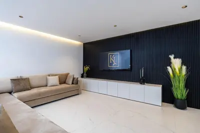 a living room with a couch and a tv on a wall at Duplex piscine privée chauffée Rooftop in Marrakech