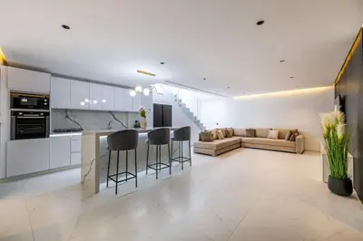 a kitchen and living room with a counter and stools at Duplex piscine privée chauffée Rooftop in Marrakech