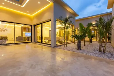 a house with a courtyard with palm trees at Villa luxueuse sans vis à vis - Piscine chauffée in Marrakech