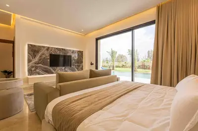 a bedroom with a large bed and a large window at Villa luxueuse sans vis à vis - Piscine chauffée in Marrakech
