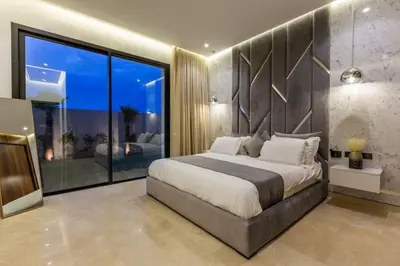 a bedroom with a large bed and a large window at Villa luxueuse sans vis à vis - Piscine chauffée in Marrakech