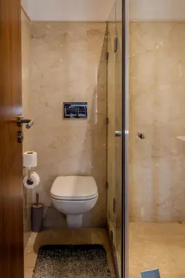 a bathroom with a toilet and a glass shower at Oasis urbaine - Pearl Garden luxe et confort in Marrakech