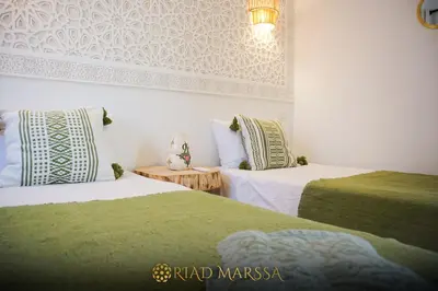 two beds sitting next to each other in a room at Riad Marssa, Privé Zen avec belle piscine dans la Médina in Marrakech