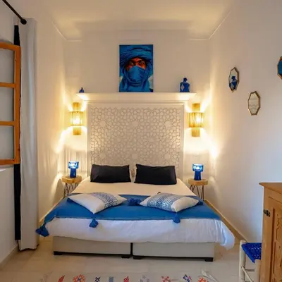 a bedroom with a bed and a painting on the wall at Riad Marssa, Privé Zen avec belle piscine dans la Médina in Marrakech