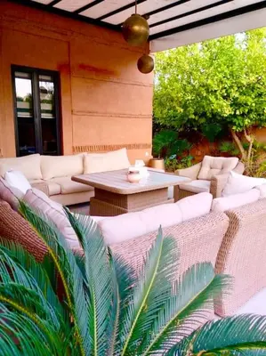 an outdoor patio with white couches and a table at Villa beldi chic Amelkis golf in Marrakech