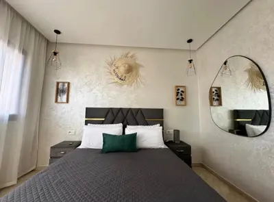 a bedroom with a large bed and a mirror at Appartement chic et cosy en plein centre de Gueliz in Marrakech